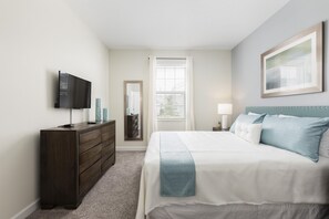 A bedroom with a bed, dresser, TV, and a window with blinds. - Tropical Escape by Orlando Short Term (Davenport)