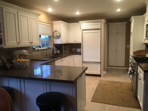 Enjoy cooking in this well-equipped kitchen with a central island, oven, and stainless steel appliances.