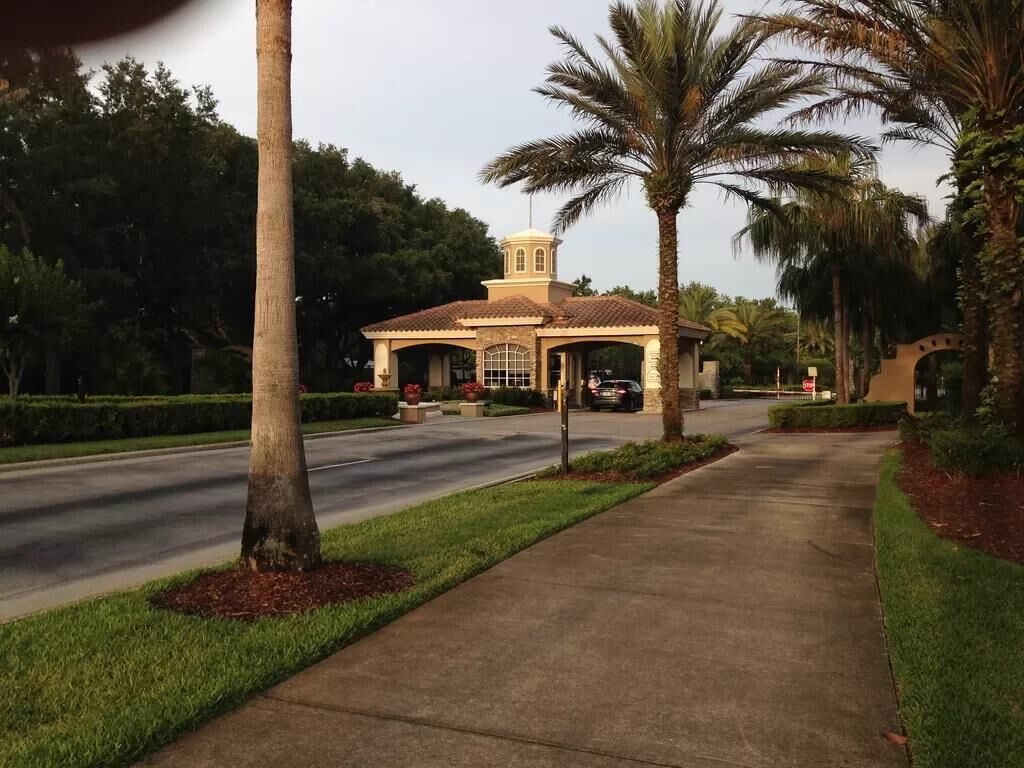 A building with a tiled roof, a small tower, and a paved walkway.