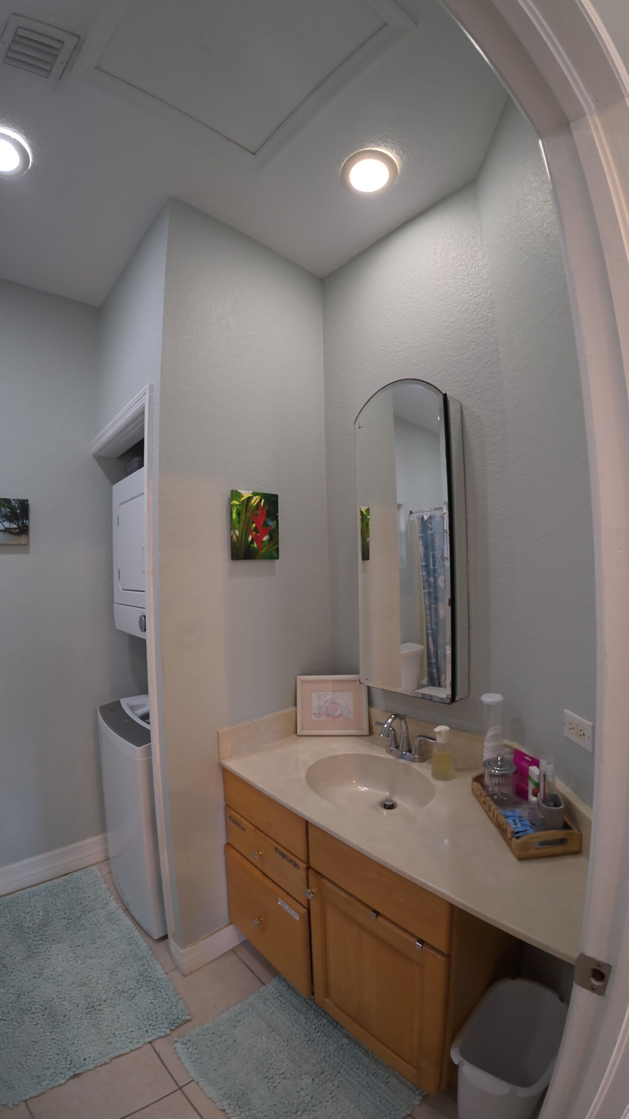 A bathroom with a sink, mirror, and towel rack.