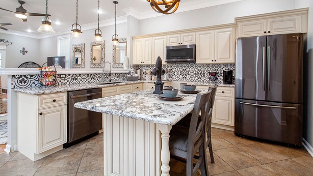 A kitchen with a central island, stainless steel appliances, and decorative lighting. - Rent My NOLA Jewel, Luxury Accommodations (New Orleans)