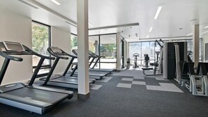 A modern gym with treadmills, weight machines, and a large window providing natural light. - Chic 1BR | Rooftop Terrace  | Pool | Mountain View (Mountain View)