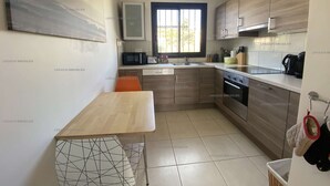 A modern kitchen with wooden cabinets, a microwave, and a sink.