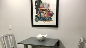 A framed artwork of Sarasota, Florida, on a wall above a table with two chairs. - Private Updated Mother In Law Apartment with Fenced Yard 4 miles from Siesta Key (Sarasota)