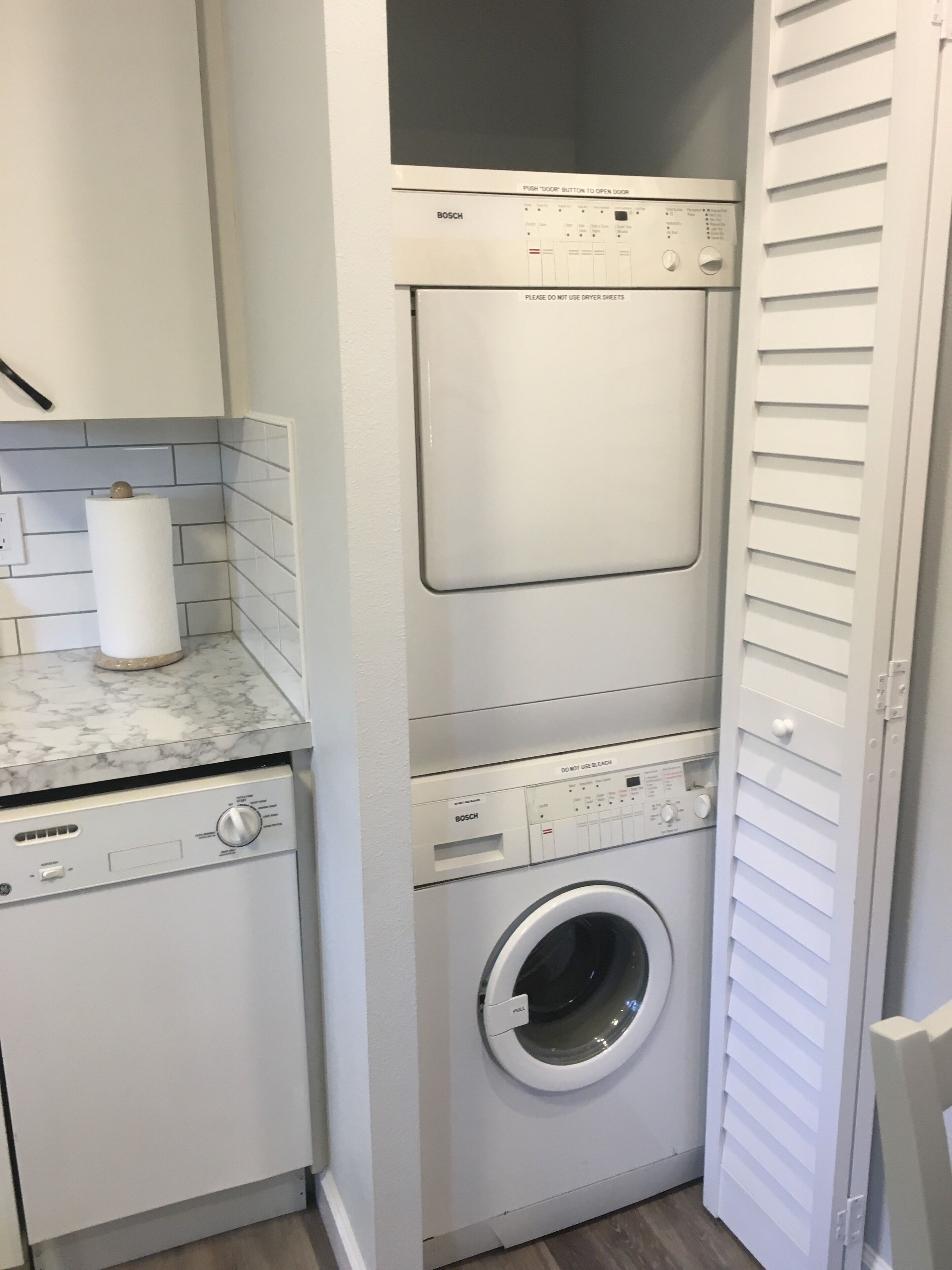 Un espace buanderie compact comprenant un lave-linge, un sèche-linge et un appareil combiné lave-linge et sèche-linge.