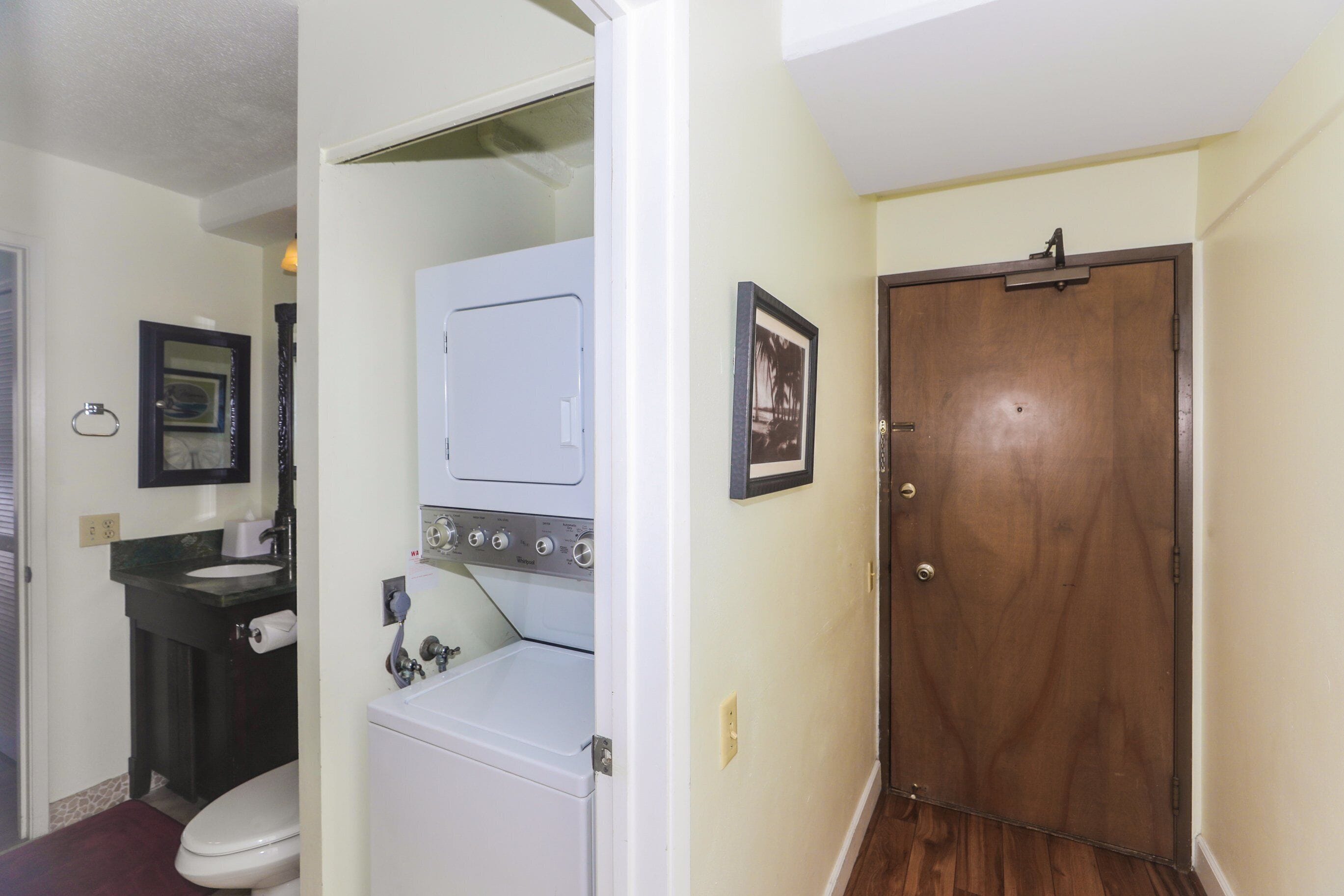 A laundry room with a washer and dryer, a sink, and a toilet.