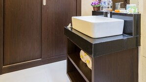 A bathroom with a wooden wardrobe, a white sink, and a mirror. - The Light Bali Villa (Seminyak)
