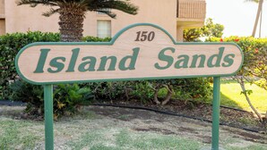 A wooden sign with "Island Sands" and the number "150" indicating a property or location.