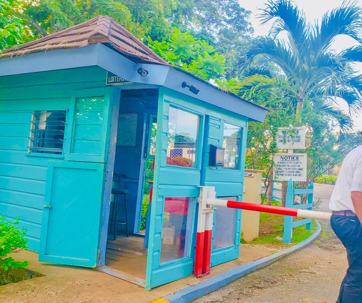 A small blue building with a door, a window, and a sign.