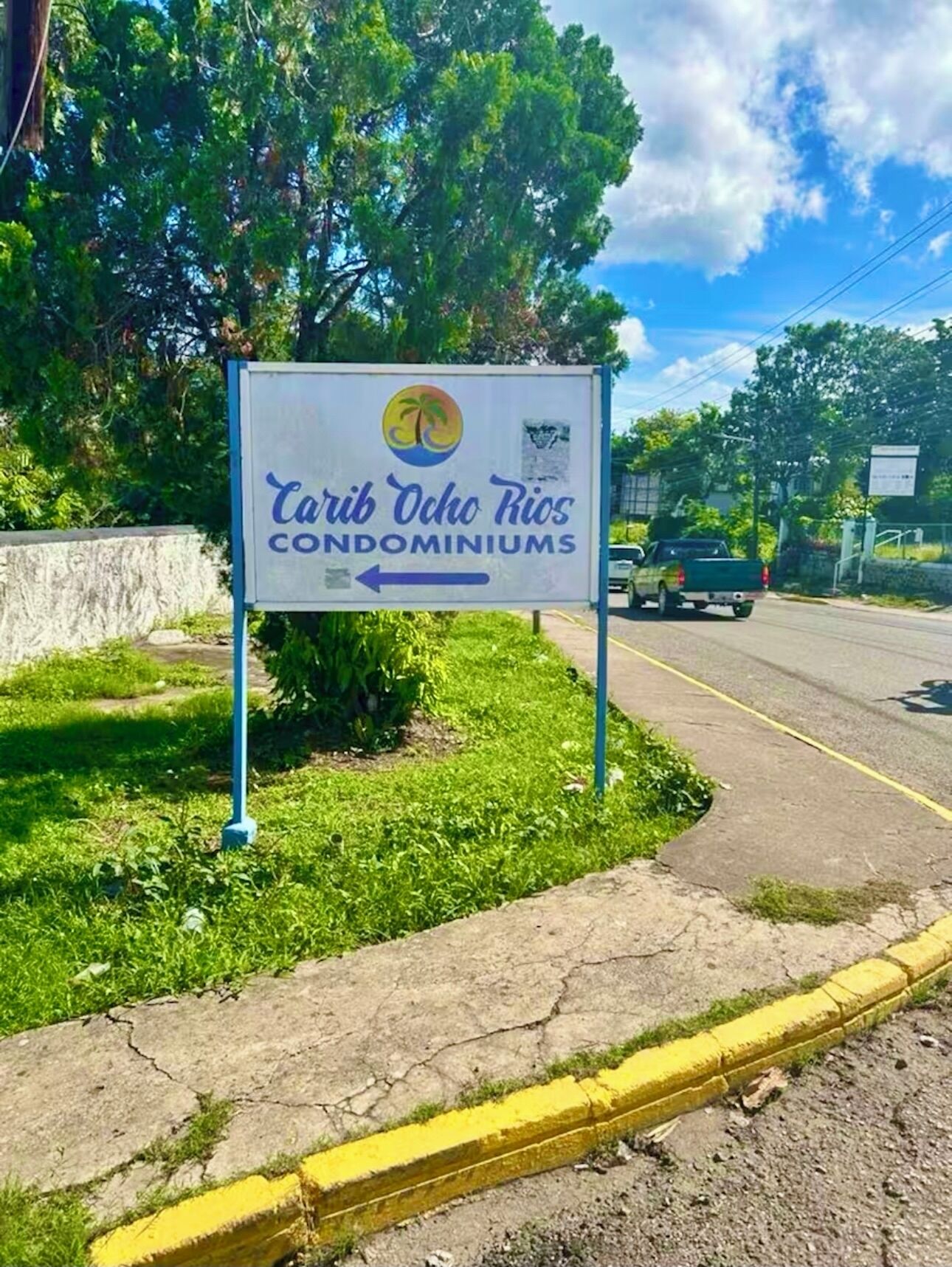 En skylt med texten ”Carib Ocho Rios Condominiums” och en pil som pekar åt vänster.