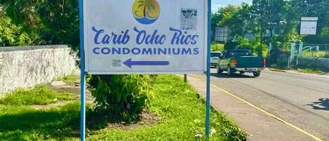 En skylt med texten ”Carib Ocho Rios Condominiums” och en pil som pekar åt vänster.