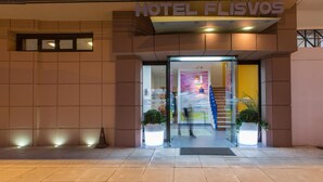 The entrance to Hotel Florvos with a modern design, featuring a glass door and a visible staircase leading inside. - Flisvos Hotel Tolo (Nafplio)