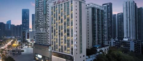 A high-rise hotel with a modern glass facade, multiple floors, and a prominent entrance.