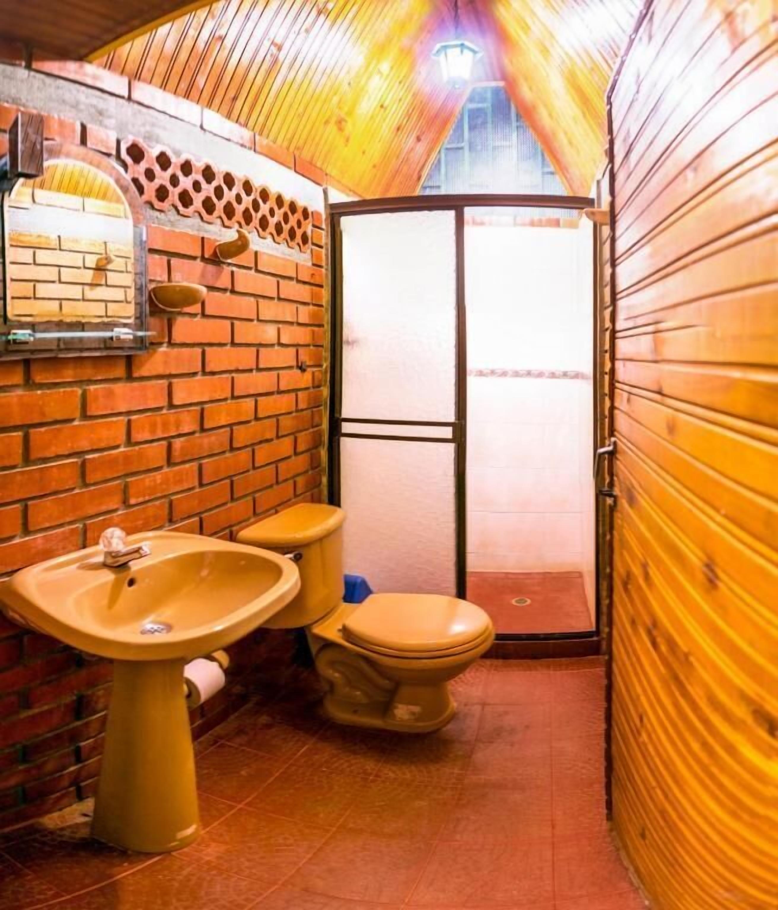A compact bathroom with a sink, toilet, and a mirror on the wall.