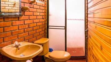 A compact bathroom with a sink, toilet, and a mirror on the wall.