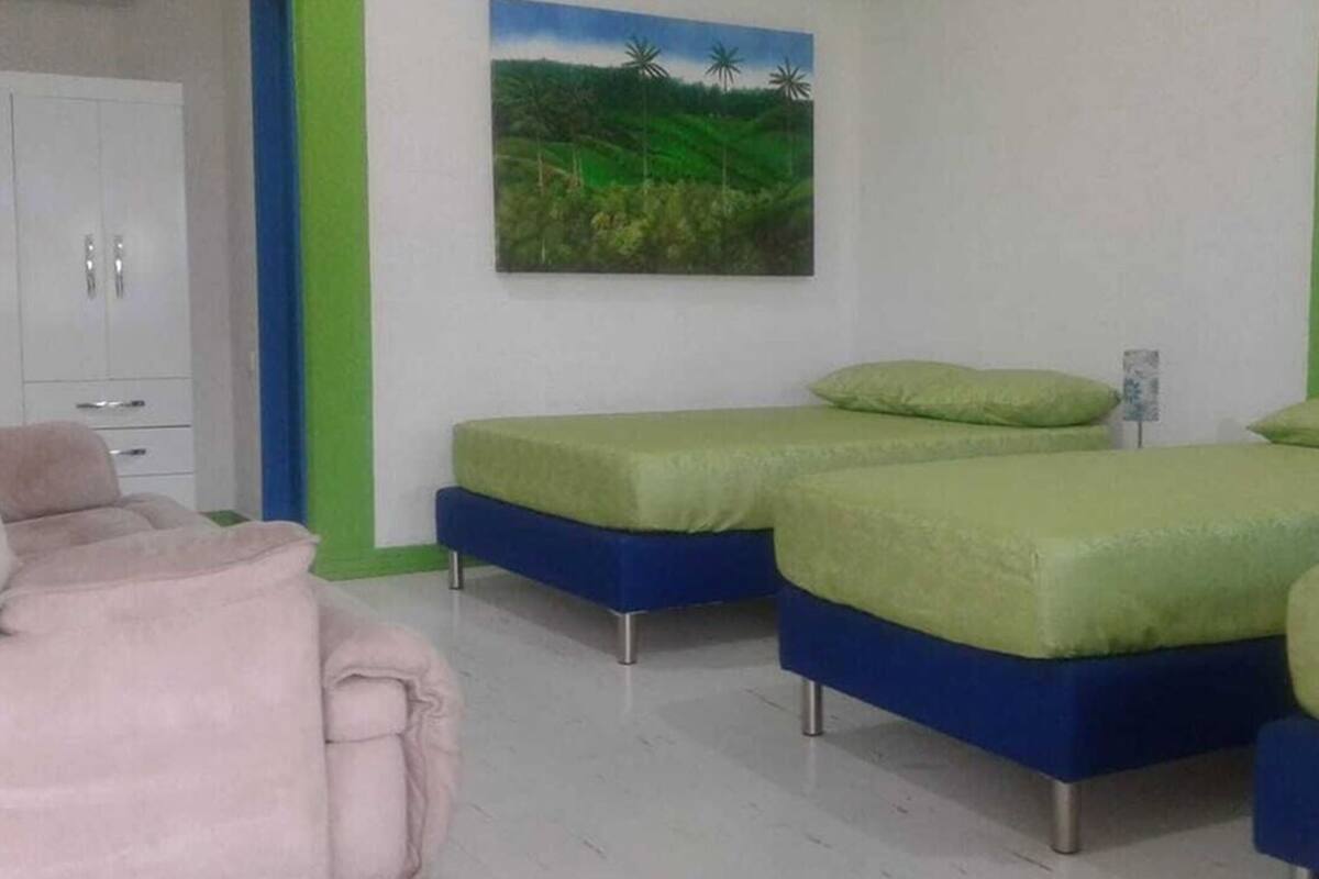 A bedroom with two single beds, a wardrobe, and a painting of a landscape.