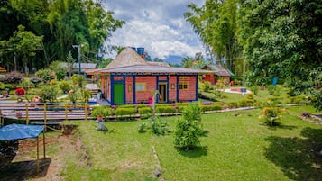 Una casa colorida con techo de paja rodeada de un jardín cuidado.