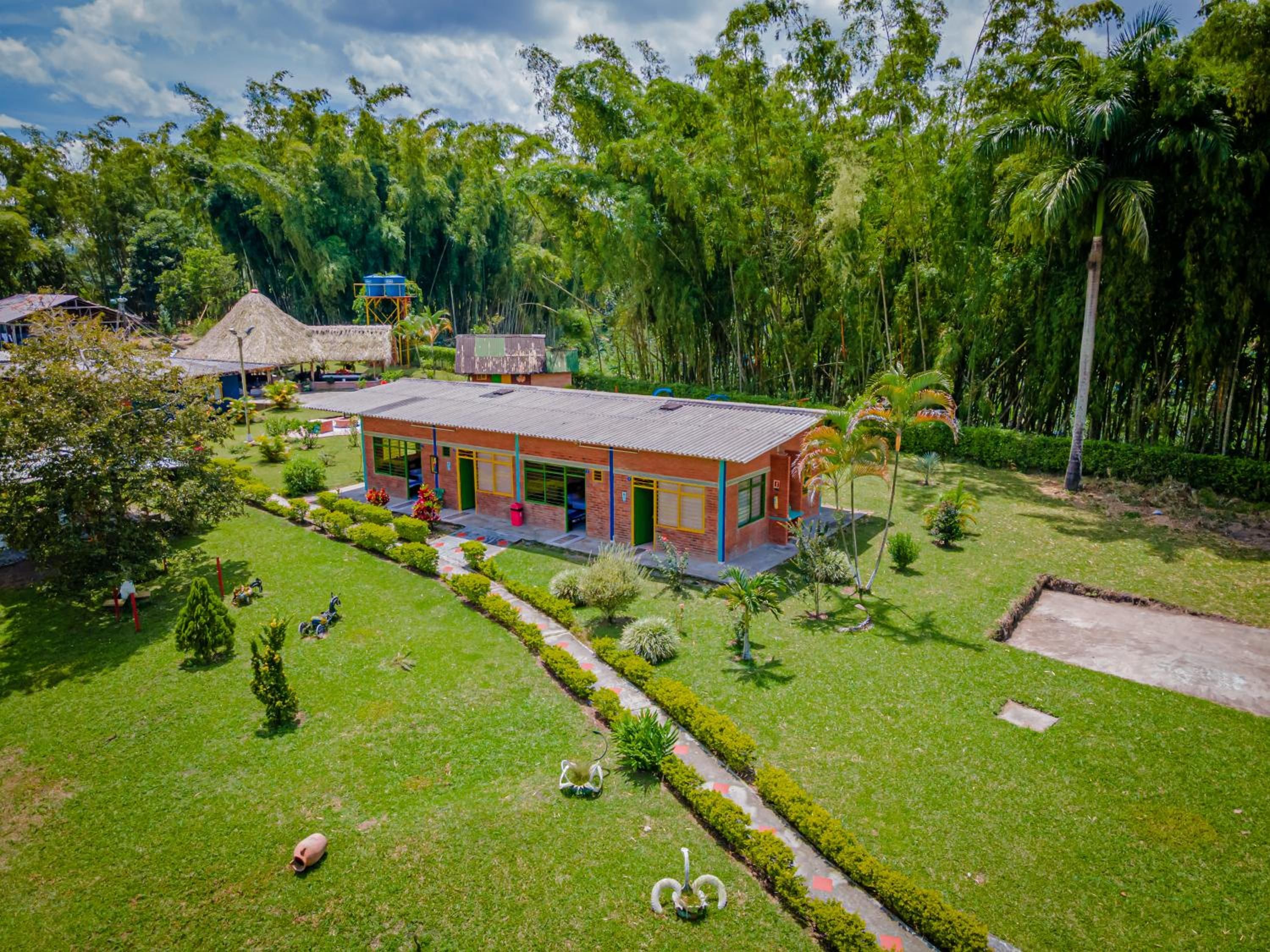 A modern building with a flat roof, surrounded by well-maintained lawns and trees.