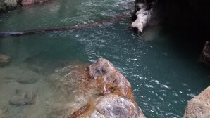 Un fiume stretto che serpeggia attraverso un profondo burrone, fiancheggiato da una fitta vegetazione.