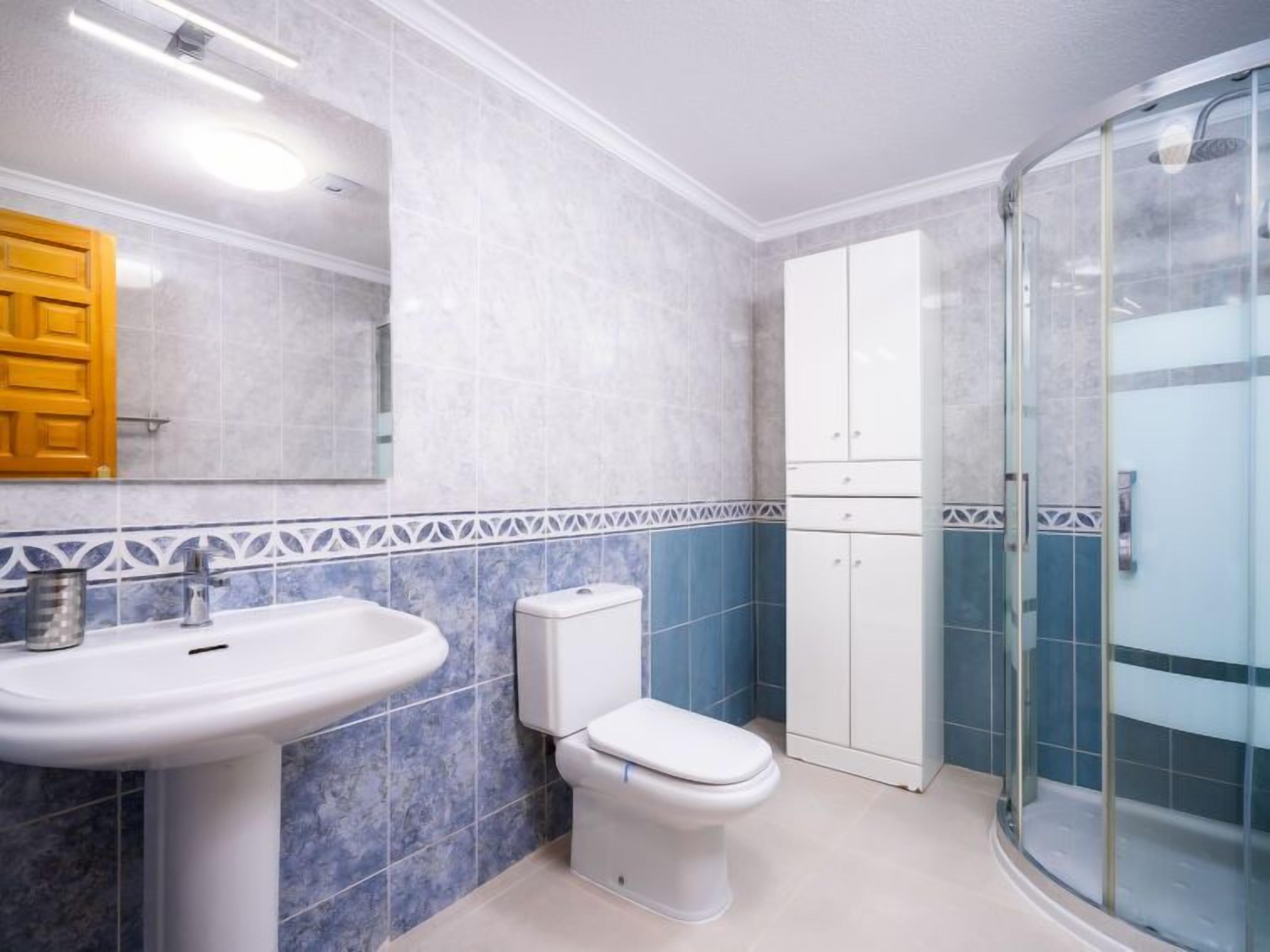 A bathroom with a sink, toilet, and shower.