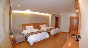 A hotel room with two beds, a seating area, and a small table. - Greentree Inn Tongxiang Chongfuzhen World Fur Cent (Jiaxing)