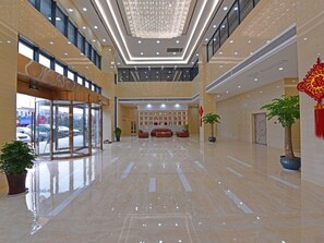 A spacious lobby with a glass entrance, a reception desk, and a chandelier. - Greentree Inn Tongxiang Chongfuzhen World Fur Cent (Jiaxing)