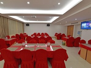 A conference room with multiple tables and chairs, equipped with a projector and a flat-screen TV. - Greentree Inn Tongxiang Chongfuzhen World Fur Cent (Jiaxing)