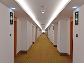 Un couloir d’hôtel avec des portes numérotées 1306 et 1303, qui donnent accès aux chambres.