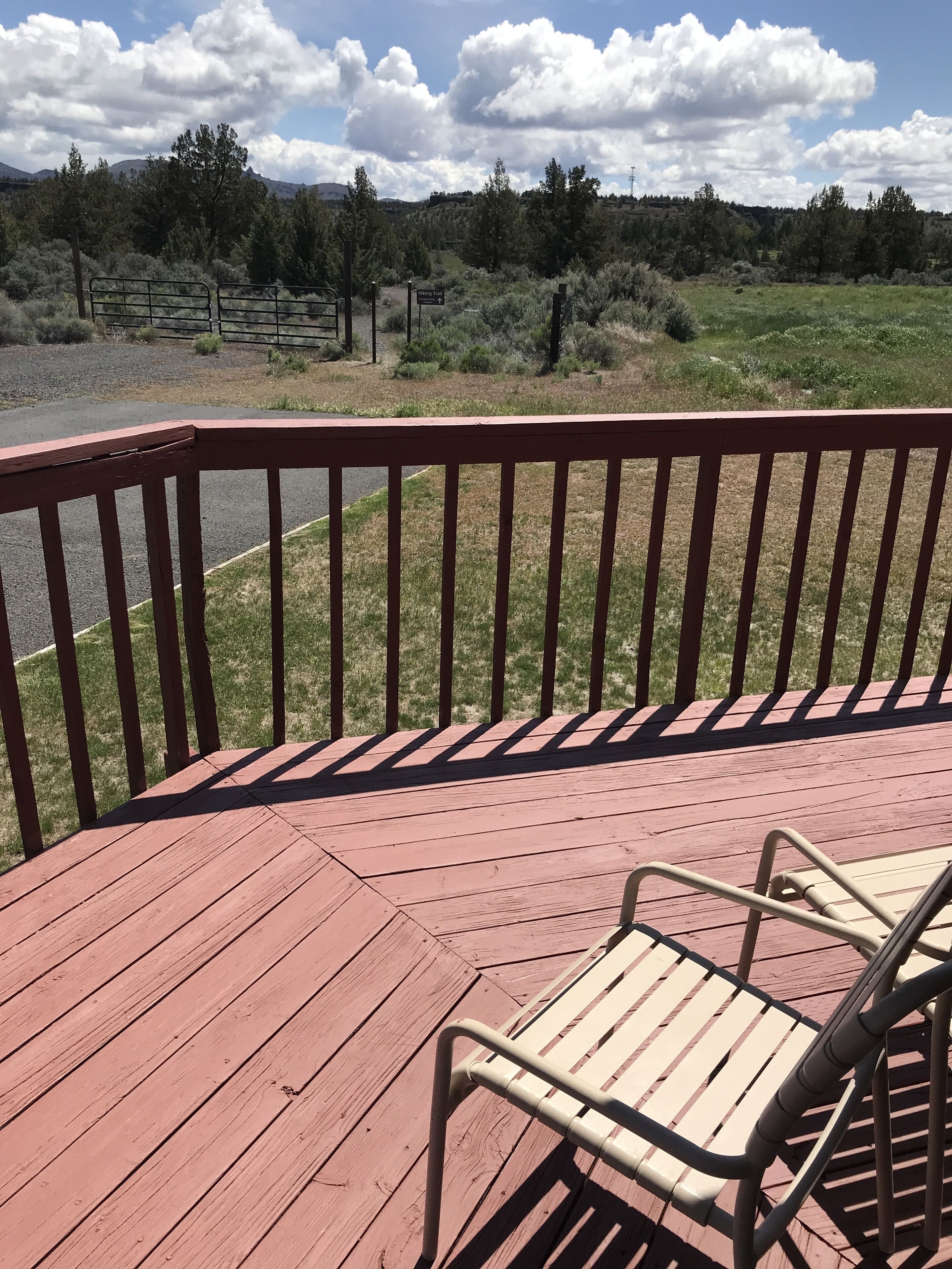 A wooden deck with a metal railing and a metal chair.