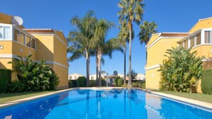 A swimming pool surrounded by yellow buildings with palm trees. - Alqueria Sol by Interhome (Dénia)