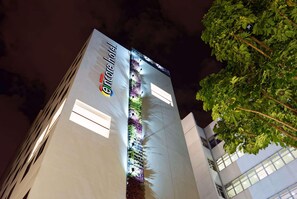 Um hotel com um jardim vertical e uma placa com a inscrição 'Elmore hotel'.