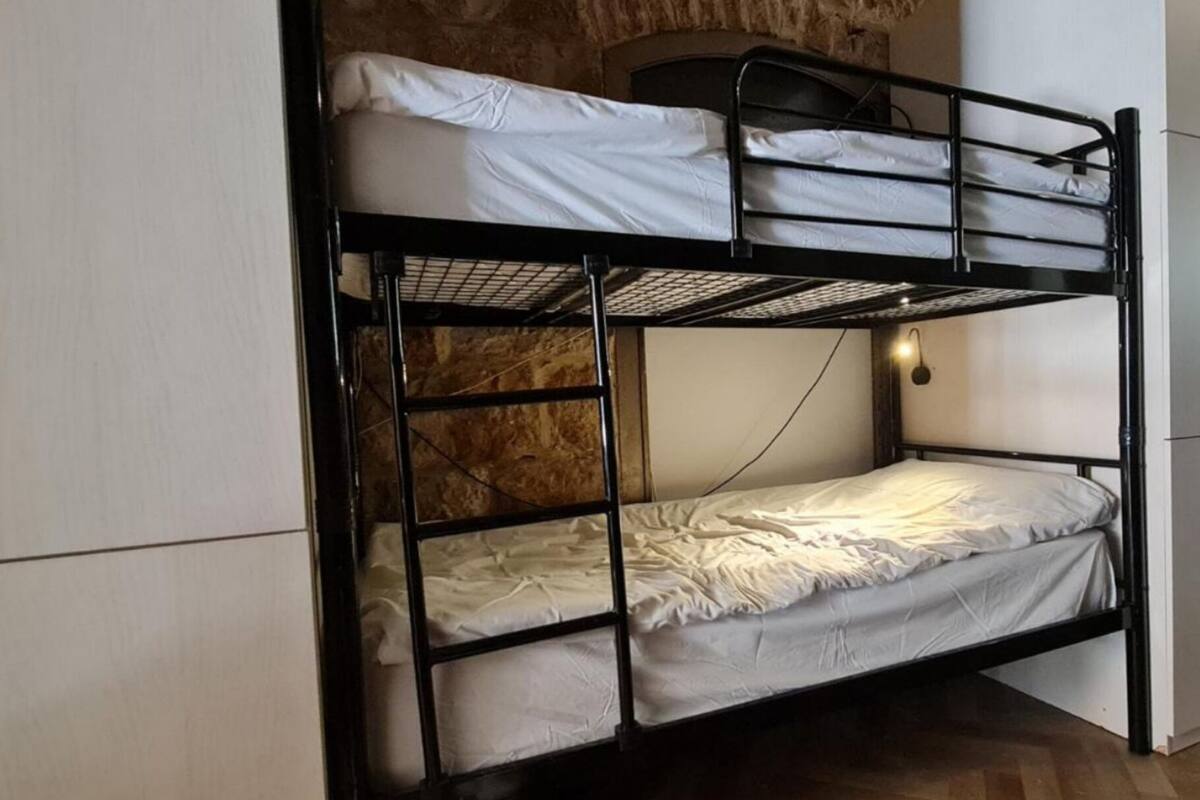 Ein Etagenbett mit Kopfteil und Wandleuchte.
