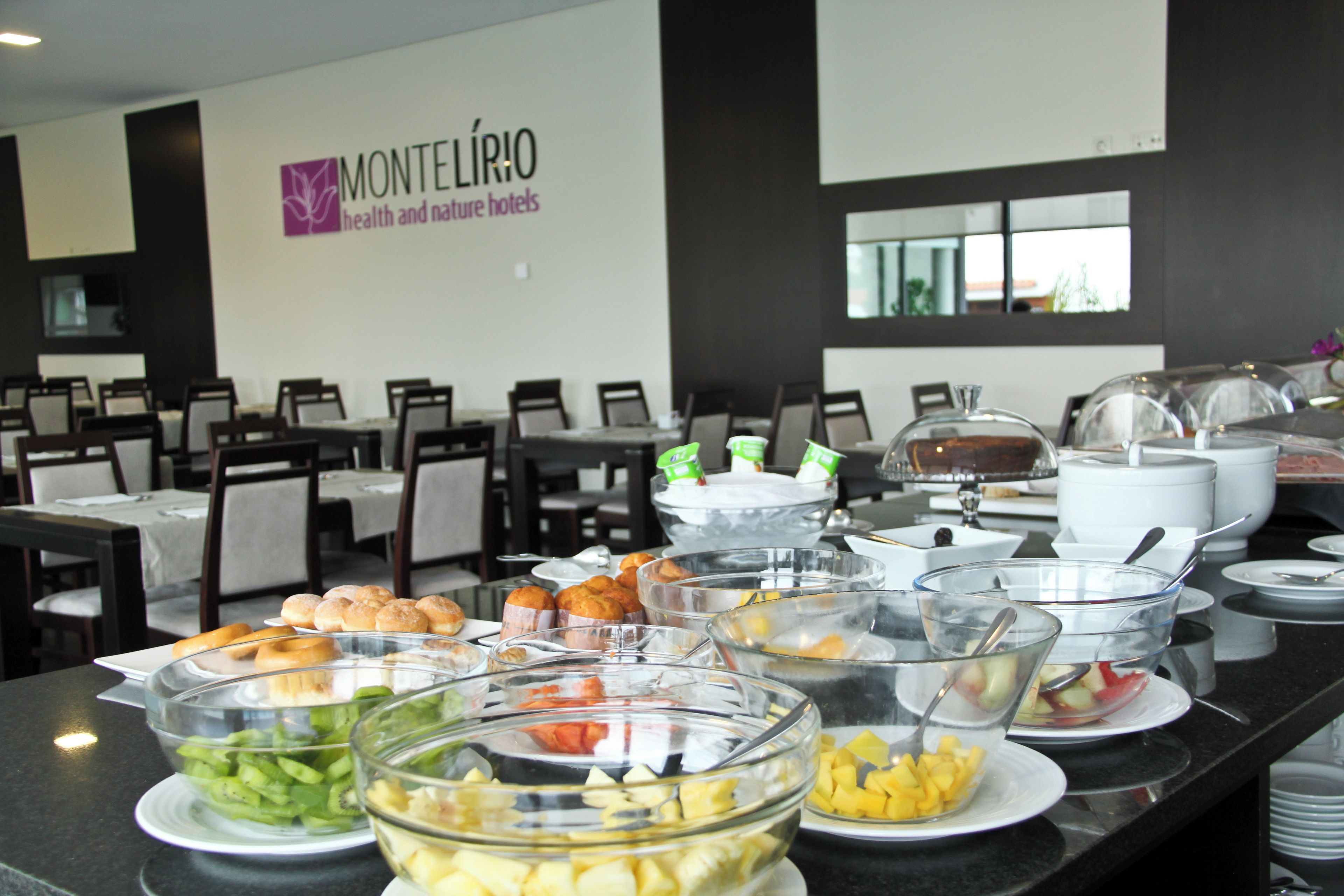 Disposição de buffet com diversos alimentos e um letreiro para hotéis Montelíbio.