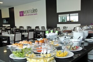 A buffet setup with various food items and a sign for Montelíbio hotels.