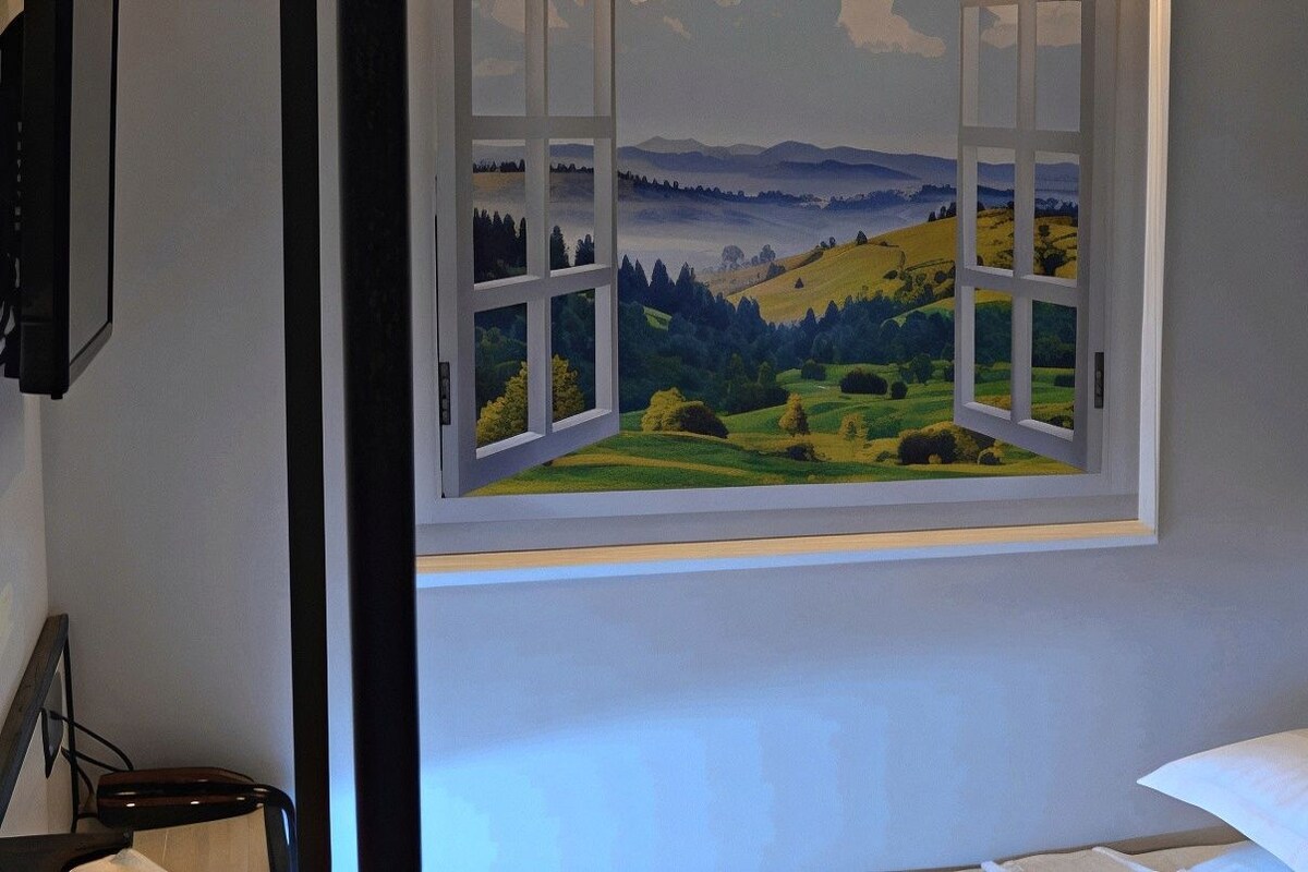 Una habitación con un ventanal que ofrece vistas al paisaje.