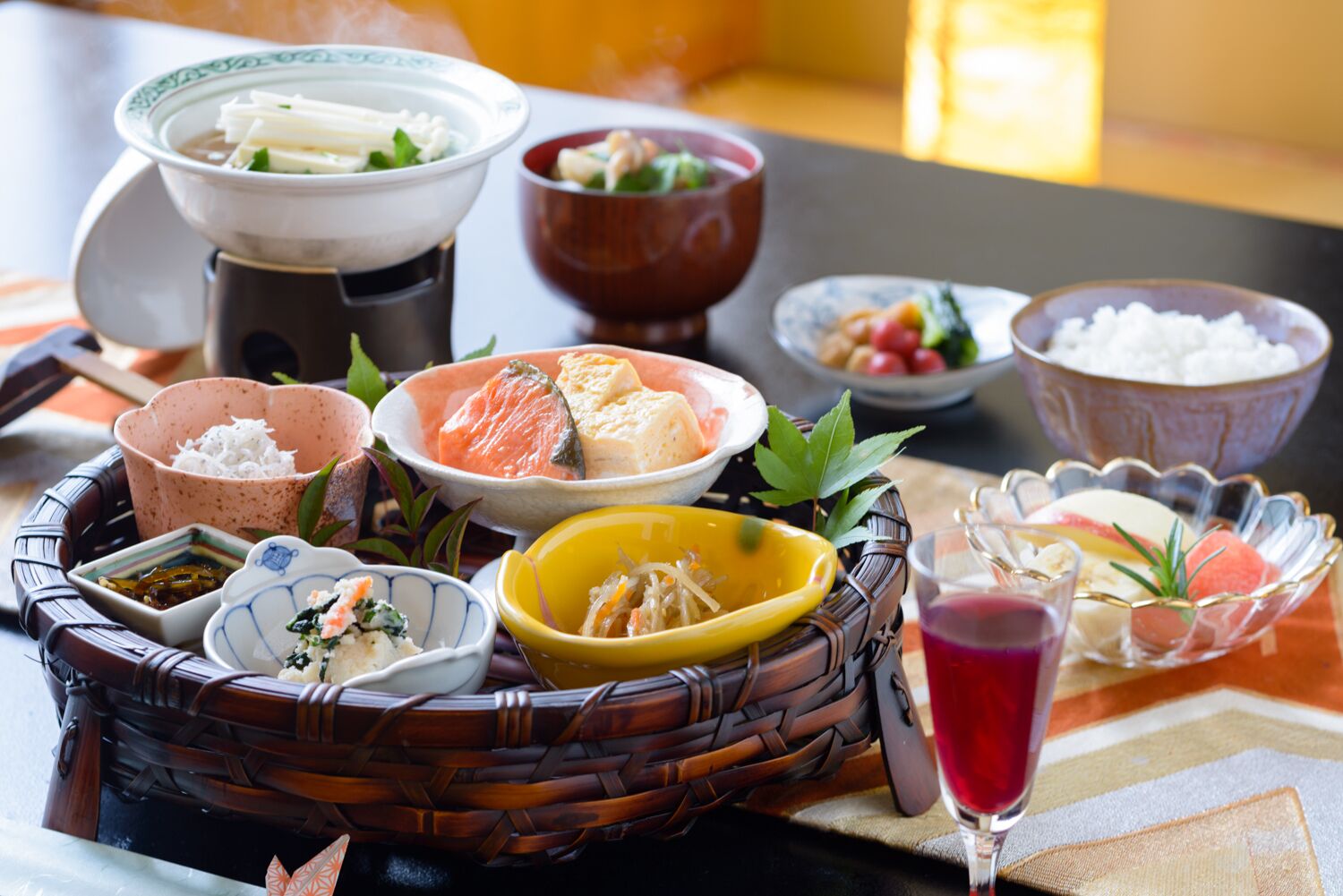 A traditional Japanese meal with various dishes and a drink.