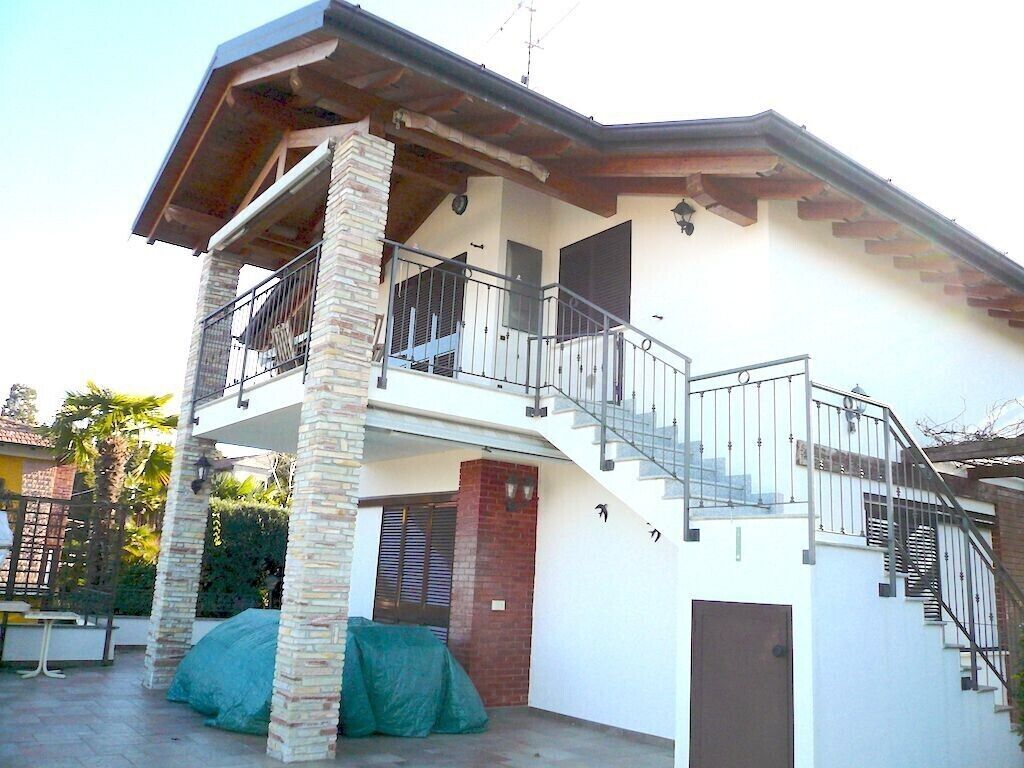 A two-story house with a balcony, a staircase, and a garage.