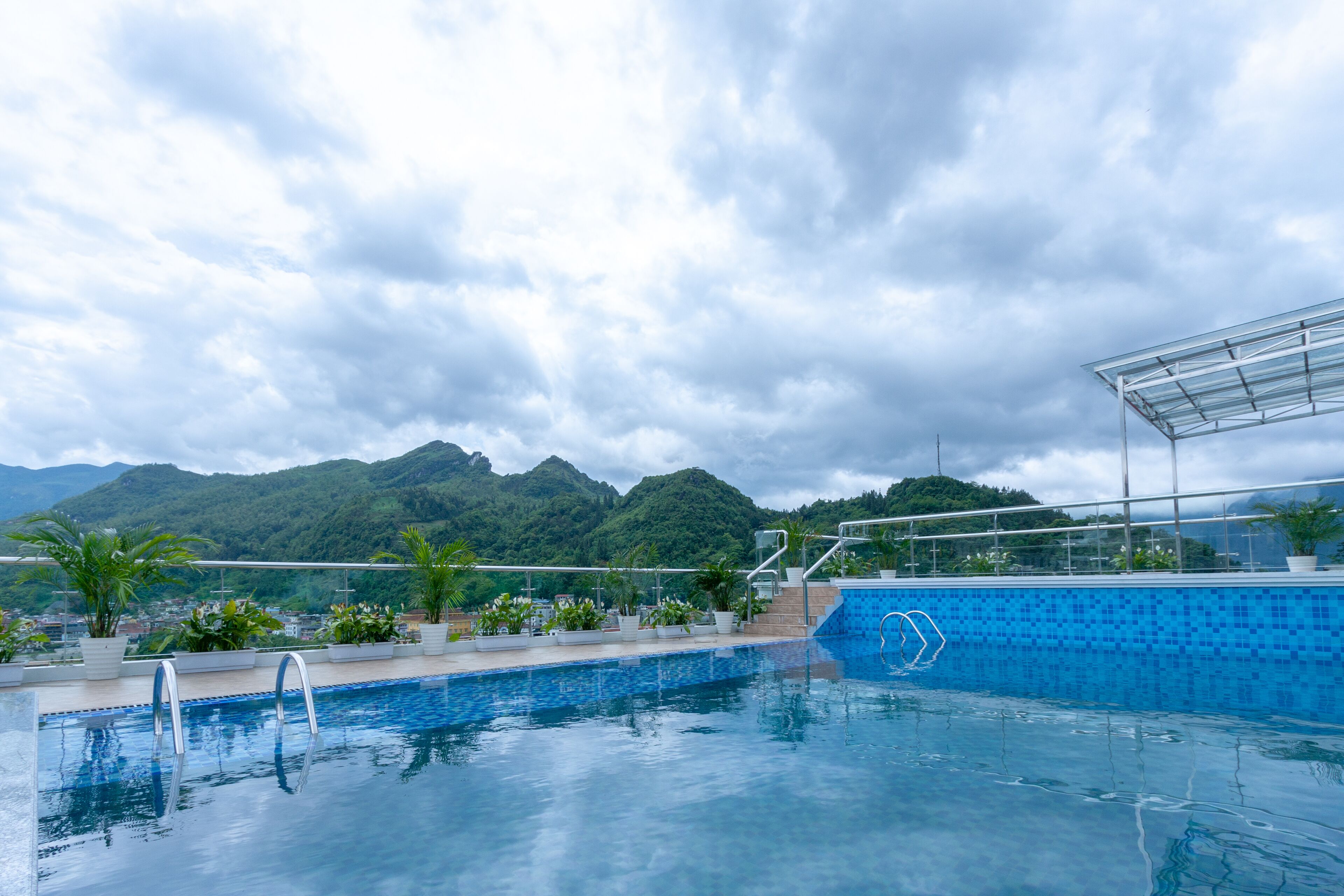Una piscina con vistas a montañas y un cielo nublado.