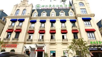 A hotel with a classic European architectural style, featuring a symmetrical facade with multiple windows and balconies.