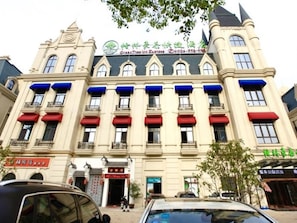 A hotel with a classic European architectural style, featuring a symmetrical facade with multiple windows and balconies. - Greentree Inn Anqing Duxiu Avenue Greenland Metrop (Anqing)