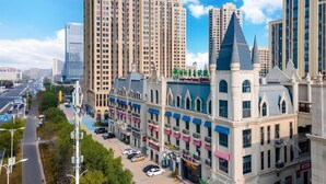 A hotel with a central tower, multiple stories, and a parking lot. - Greentree Inn Anqing Duxiu Avenue Greenland Metrop (Anqing)