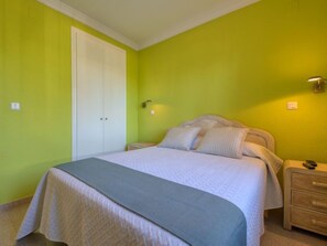 A bedroom with a bed, bedside tables, and a wardrobe.