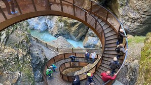 Una escalera de caracol con vistas a un desfiladero rocoso y un río.