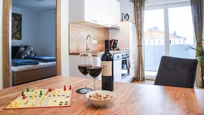 Una habitación acogedora con una mesa de madera, un tablero de ajedrez, copas de vino y una botella.