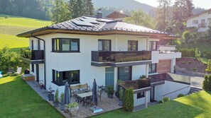 Relax on the spacious deck with outdoor furniture, surrounded by a well-maintained garden and beautiful views.