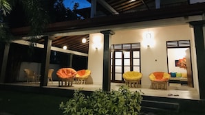 A covered outdoor seating area with chairs and a potted plant. - Ravan Tangalle (Tangalle)