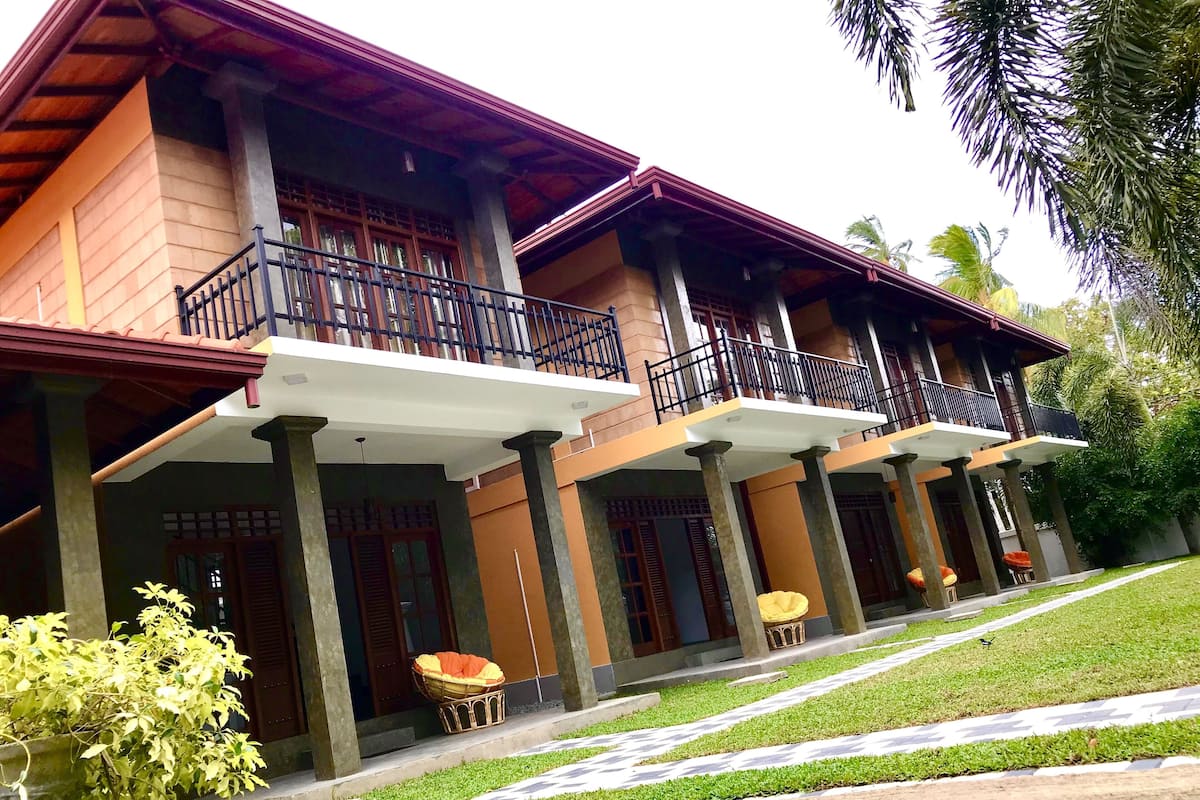 A multi-story building with balconies and a covered walkway.