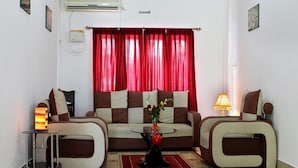 A living room with a sofa set, a coffee table, and a red curtain. - The Shelter Hotel - Port Blair (Port Blair)