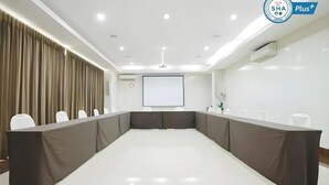 A conference room with a long table, white chairs, a projector screen, and a whiteboard. - Ratchaphruek Pavilion (Nakhon Pathom)