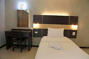 Ein Hotelzimmer mit Bett, Schreibtisch und Stuhl.